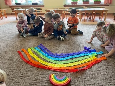 grupa dzieci przedszkolnych podczas zajęć z eksperymentem z kolorowych cukierków