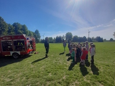 grupa dzieci przedszkolnych podczas wizyty strażaków
