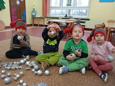 grupa dzieci przedszkolnych podczas ubierania choinki