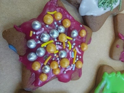 grupa dzieci przedszkolnych podczas dekorowania pierniczków bożonarodzeniowych