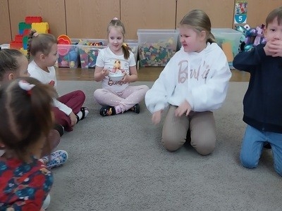 grupa dzieci przedszkolnych podczas zabaw badawczych ze solą na zajęciach