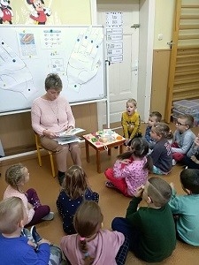 pielęgrniarka pokazuje dzieciom ilustracje tematyczne 