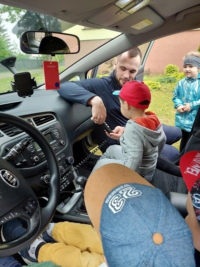 policjant opisuje dzieciom wyposażenie samochodu 