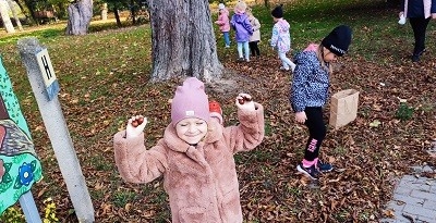 dzieci zbierają dary jesieni w parku 